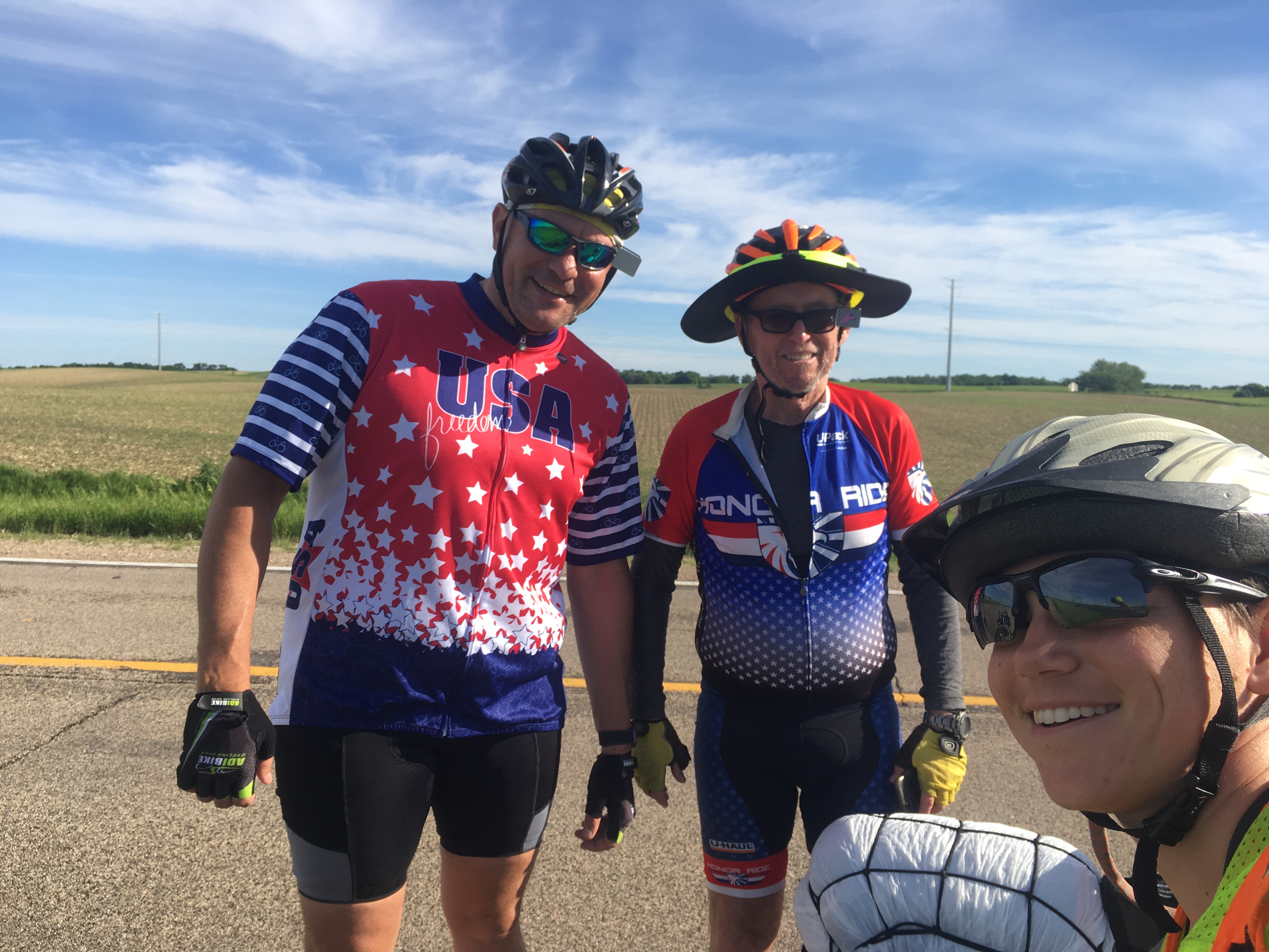 A selfie of Zeph with two
(much more serious-looking) touring cyclists, with a road and empty field
in the background.