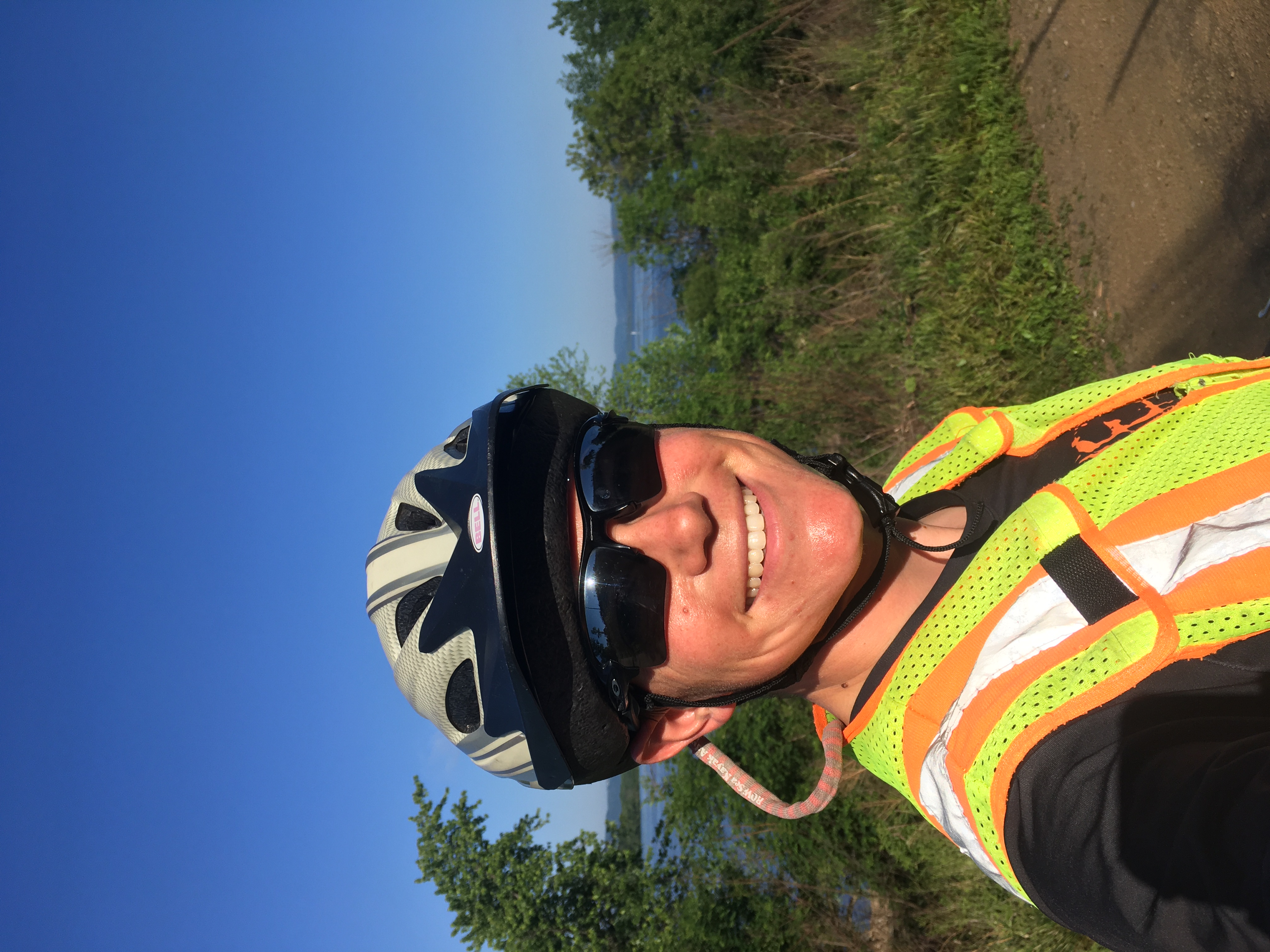 Zeph, in sunglasses, reflective vest, and helmet, in front of that same view