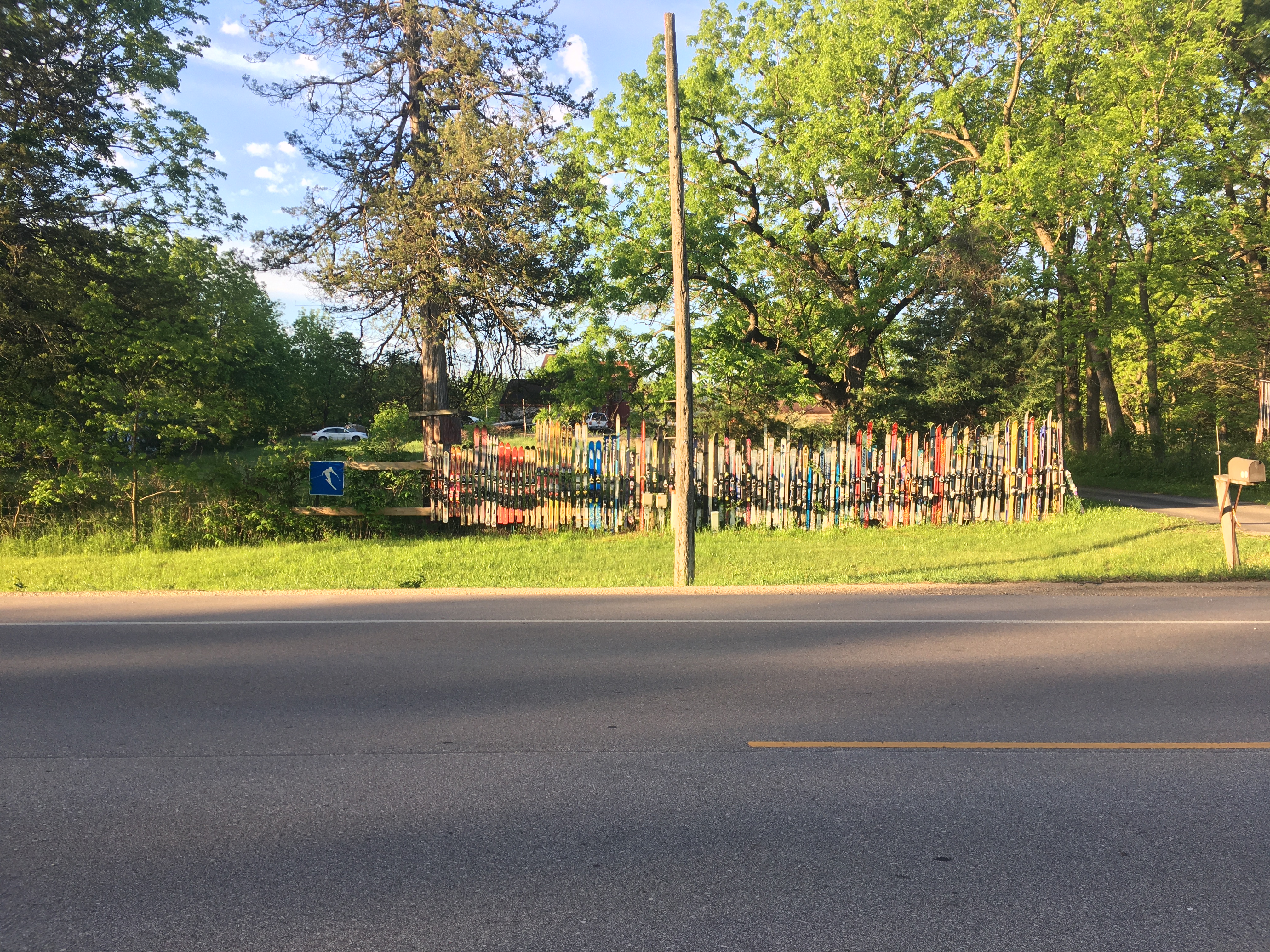 A yard and fence. The fence is
made of wood, like normal fences, but also lined with dozens of pairs of
skis of different lengths.