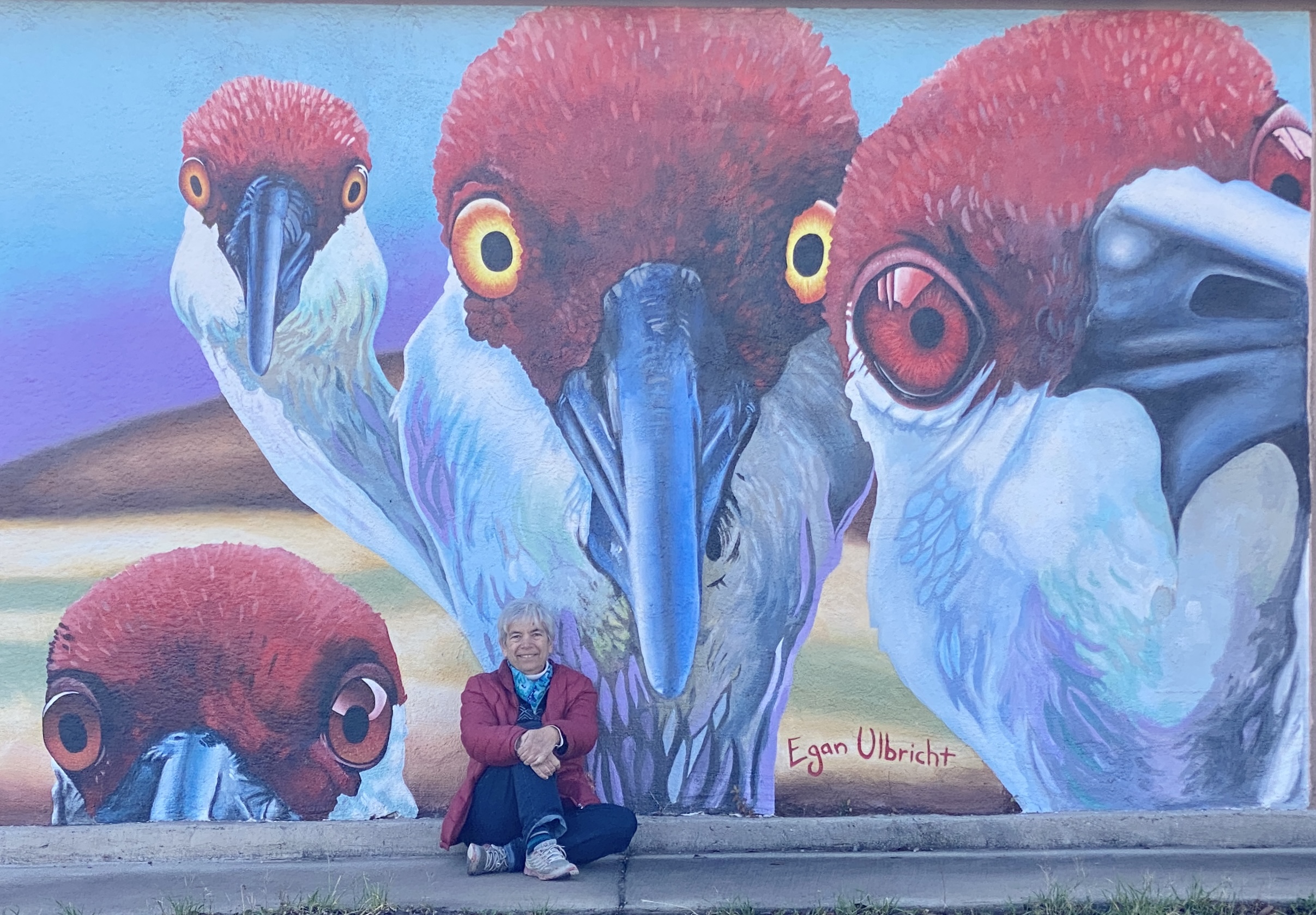 Newenka in front of a sandhill crane mural in NM